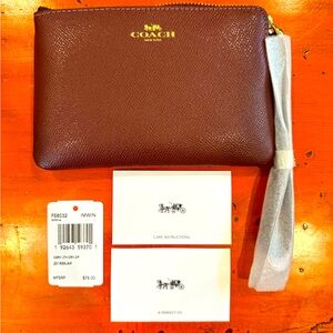 NEW Coach wristlet with tag and original packaging in rich burgundy.